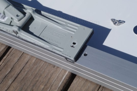 Because only so much can safely be hacked off, the pad must also be relocated by drilling new mounting holes. Presto, no protrusion.