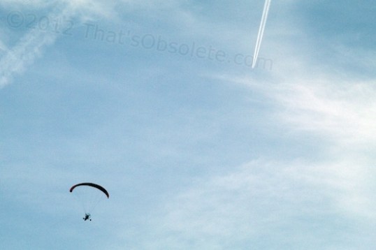 Notice the jet and its trail. As is always the case, the more primitive form of transport gives the true sensation of flying high above the ground, while the technological approach insulates one from the wonderment of flight.