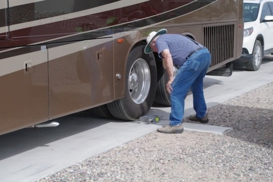 George and an accomplice read scales and note the numbers on a clipboard.