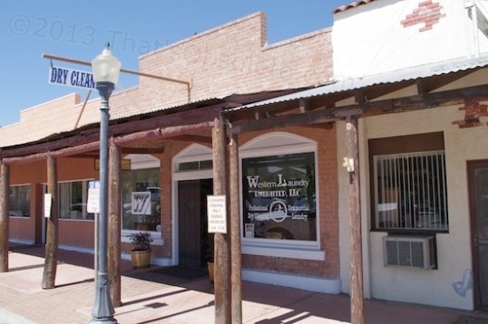 This dry cleaners shop used to be the 1930 Post Office. The roofed sidewalk is a relatively recent addition. Originally, one of the windows was a "drive up" service window used to give people riding up on horseback their mail.