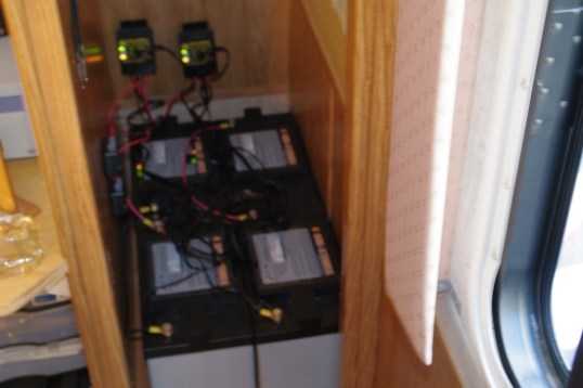 The Office closet. In this original setup, the four batteries are divided into two pairs, with two inexpensive controllers, since each solar panel can’t rapidly charge more than two batteries, and each controller can only handle one panel.