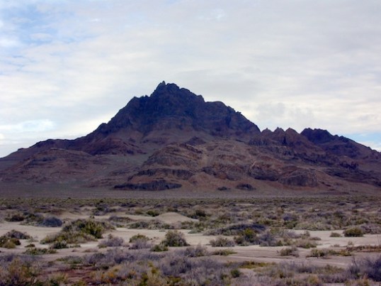 The trail wound its way beside a range of mountains, with flat plains on the other side.
