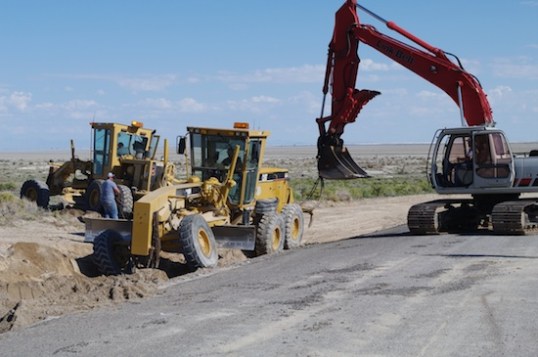 With wheels spinning and two vehicles pulling, the stuck grader was freed without damage.