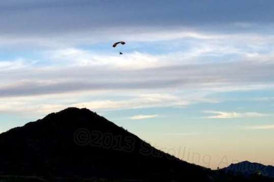 One of two engine-powered hang gliders lazily makes for home at sunset.