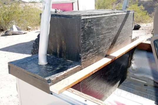 This wood box is deceptive. The upper half is a metal-lined gas tank for the generator or driving. The lower half is a storage compartment.