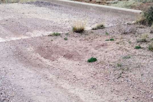 A deep sinkhole showing no signs of breaking through any pavement, and a clean concrete surface with nothing but mudstains. Not a speck of tar?