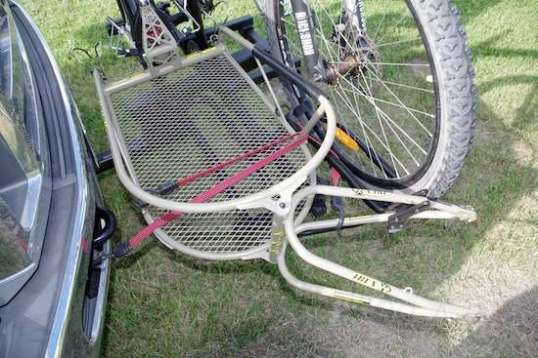 One strap gently pulls the trailer toward the bike and aligned, while the other pulls it away from the bike's front axle stub and holds the trailer's fork away from the Ford's bumper. 
