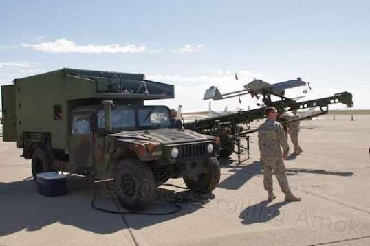An R/C model aircraft on steroids - the military version, a drone, fitted with a camera turret. Its launcher is towed by a specially-outfitted HUMVEE.