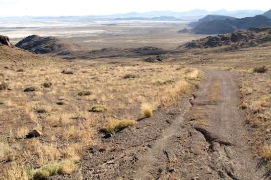 The view to the rear gives a hint of how far I came. Camp is behind and below that hill on the left. I was thankful for the twin disk brakes on the descent, since traction was iffy at times, even on the long coast down. I wouldn't have trusted rim-squeeze calipers with their rubber friction pads, due to heat buildup.