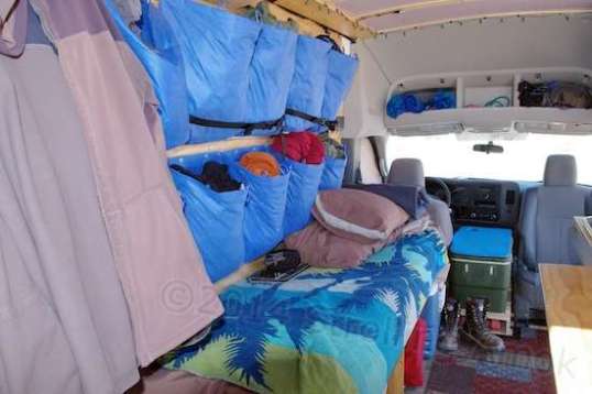 The driver's side holds the bed and soft items, with storage and a Porta-Potti below.