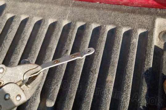 The bracket mounted directly to the headlamp is steel, and I took the "L" bend out of it with pliers.