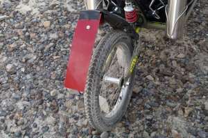 Hillbilly, anyone? This idiocy kept the salt from flinging forward into the basket. The red plastic was cut from the bottom of a kitchen sink tray. Held by the screw holing the reflector, it worked well until bumps bounced the end into the tire and wrapped it forward. If I go again next year, I'll trim its length.