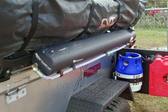 These are usually black. Fill with water, and let it sit in the sun. Then pump in a little air for pressure, grab the hose sprayhead, and take your shower! No more hefting heavy heated water bags overhead to snap off tree limbs.