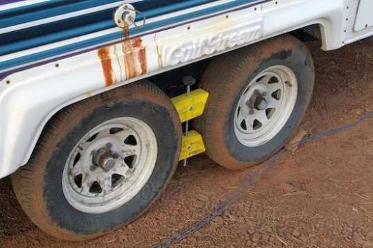 The Camco tire chock is challenged even when cranked down hard. They must be periodically re-tightened. (Those brown stains on the fender are from water at a commercial campsite in Marengo, Illinois.)