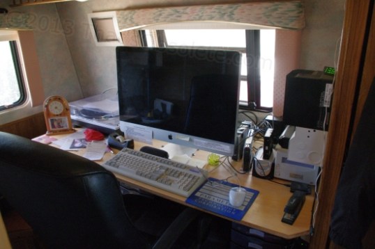 That's the Defiant's Command Center, with reference shelves directly behind the chair. With a big iMac, subwoofer, printer/scanner, a dedicated film scanner, external DVD drive and HDD drive bays, it makes a nice place to stop fighting marginal equipment and get to work.