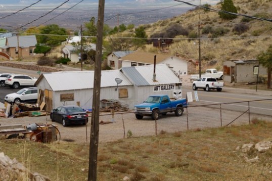 The back of this art gallery shows a popular trend in this town: windows boarded up, one after another, even in buildings still in use.