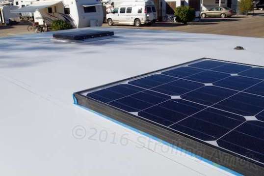 Roof beams marked in pen, the first solar panel is taped to protect paint, and placed about where it is planned to go.