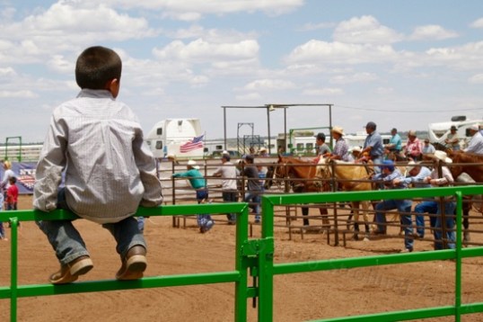 This little boy impatiently awaits the resumption of steer roping. Here, ropers don't show up, families do.