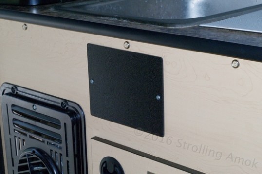 Behind this black coverplate is the junction of solar panel wires from the roof and the rear wall. Whether they should be ignored or not depends on how sophisticated a setup you're planning. At any rate, such easy access makes the task a breeze.