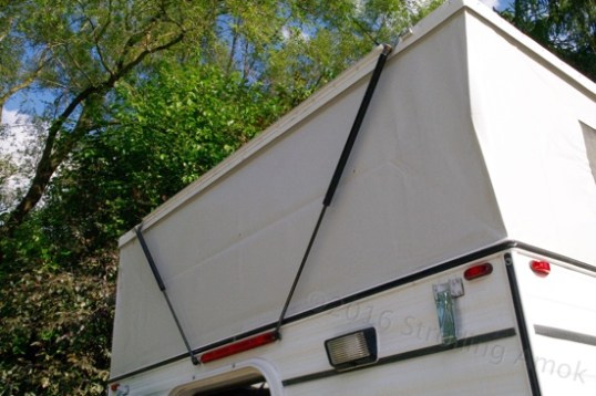 Pneumatic lifts, similar to what's used on car hatchbacks, help lift the roof. Torsion springs on each of two interior lift panels also help with the initial grunt upward, then the cylinders take over.