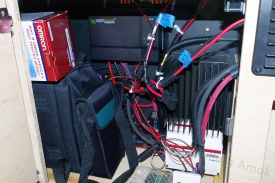 Oop. The original battery compartment has been repurposed to hold wiring junction boxes, fuses, dual solar charge controllers, a battery desulfator, and odd storage. All wiring still congregates here as if the batteries still lived here - except that they've been relocated to be inside the dining benches.