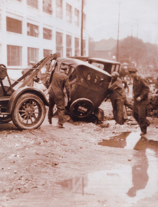 In those days, automobile clubs had bigger issues to face, given the road conditions and signage. The Flat Tire Club changed its name to the Hoosier Motor Club in 1911, and that's one of their tow trucks yanking out this car that has a wheel caught in an epic rut. ..And we think potholes are bad!